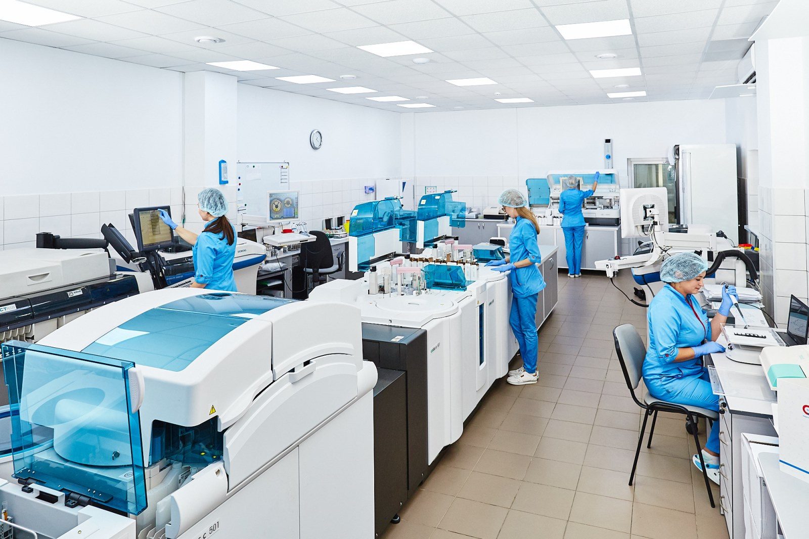 Laboratory technicians running samples across automated analyzers